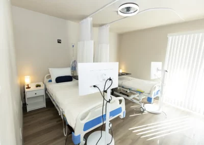 A patient room with two beds and a large window
