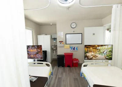 A patient room with two beds and a large window