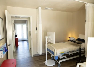 A patient bed with a TV screen and privacy curtains