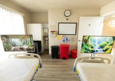 A patient room with two beds and a large window