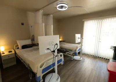 A patient room with two beds and a large window