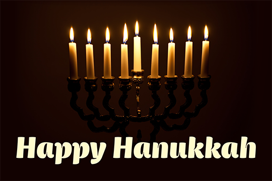 Happy Hanukkah card with lit menorah and dark background