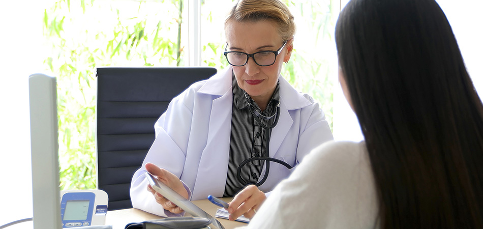 A doctor and patient going over information together in an office.