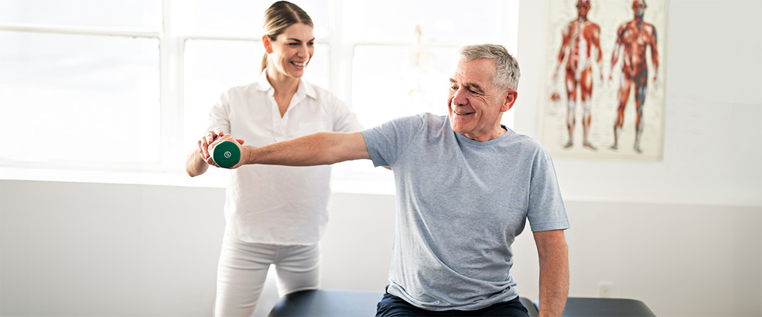 Rehab Therapist working with a man lifting a weight