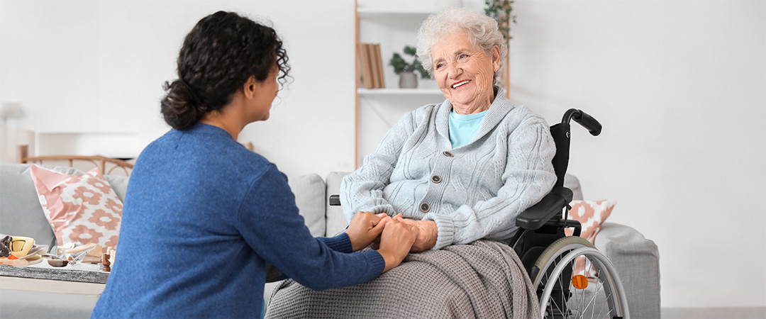 Healthcare worker talking with woman in wheelchair