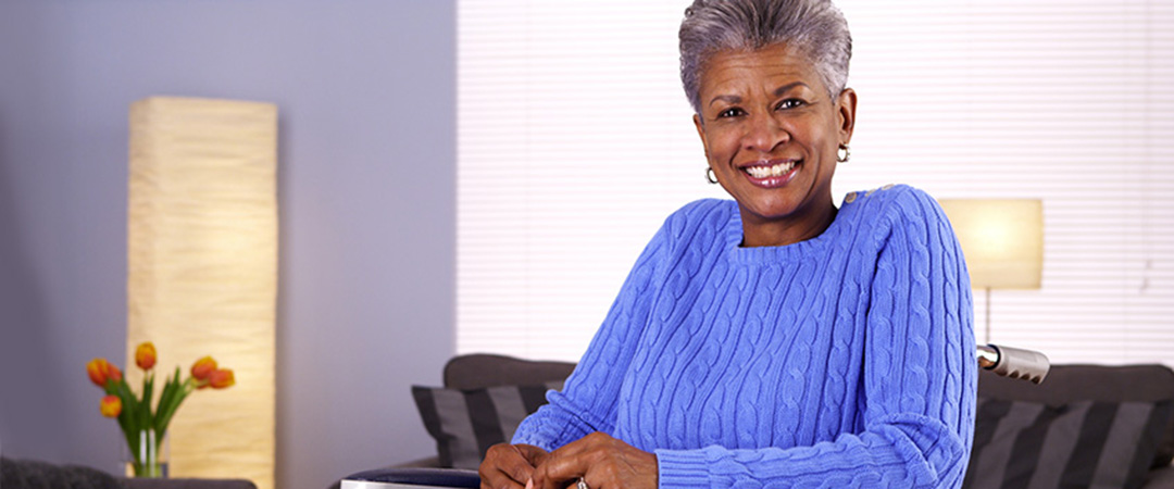 An elderly woman in a wheelchair smiling