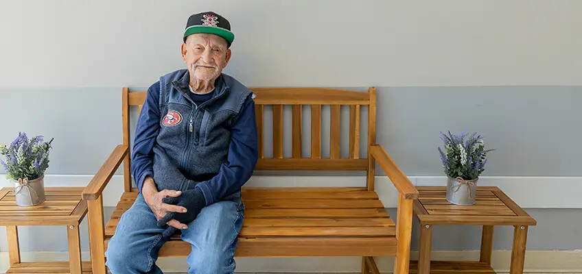 A resident sitting on a bench at Los Banos