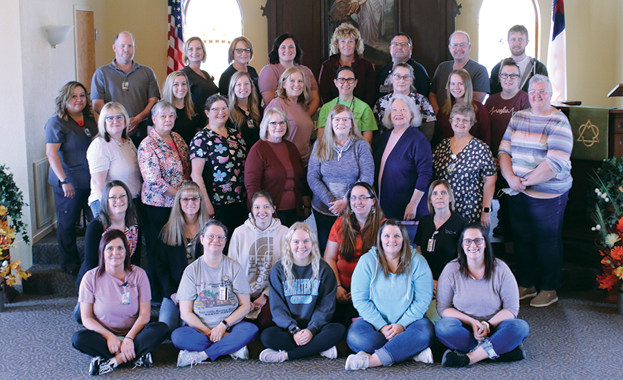 Lutheran Home staff members with chapel background