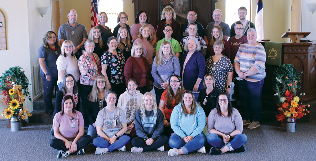 Lutheran Home staff members with chapel background