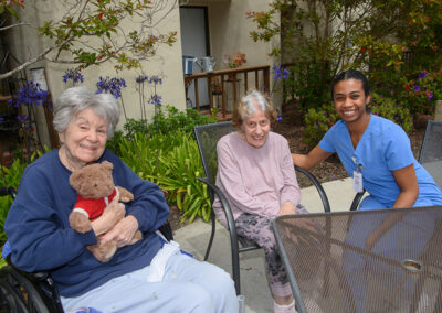 Residents sitting outside together with a nurse at Carmel Hills
