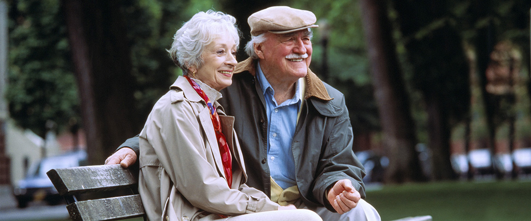 Mature couple sitting outside in jackets