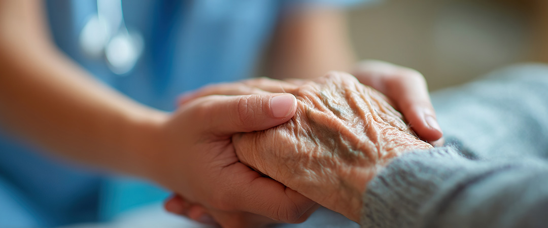 Caregiver holding hand of older person