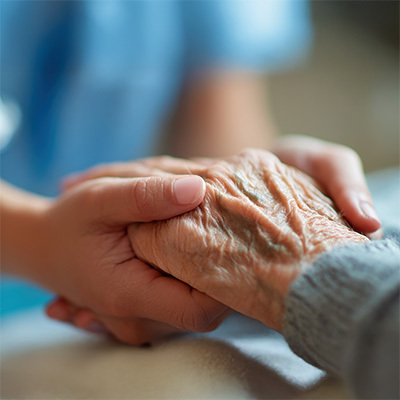Caregiver holding the hands of an elderly person