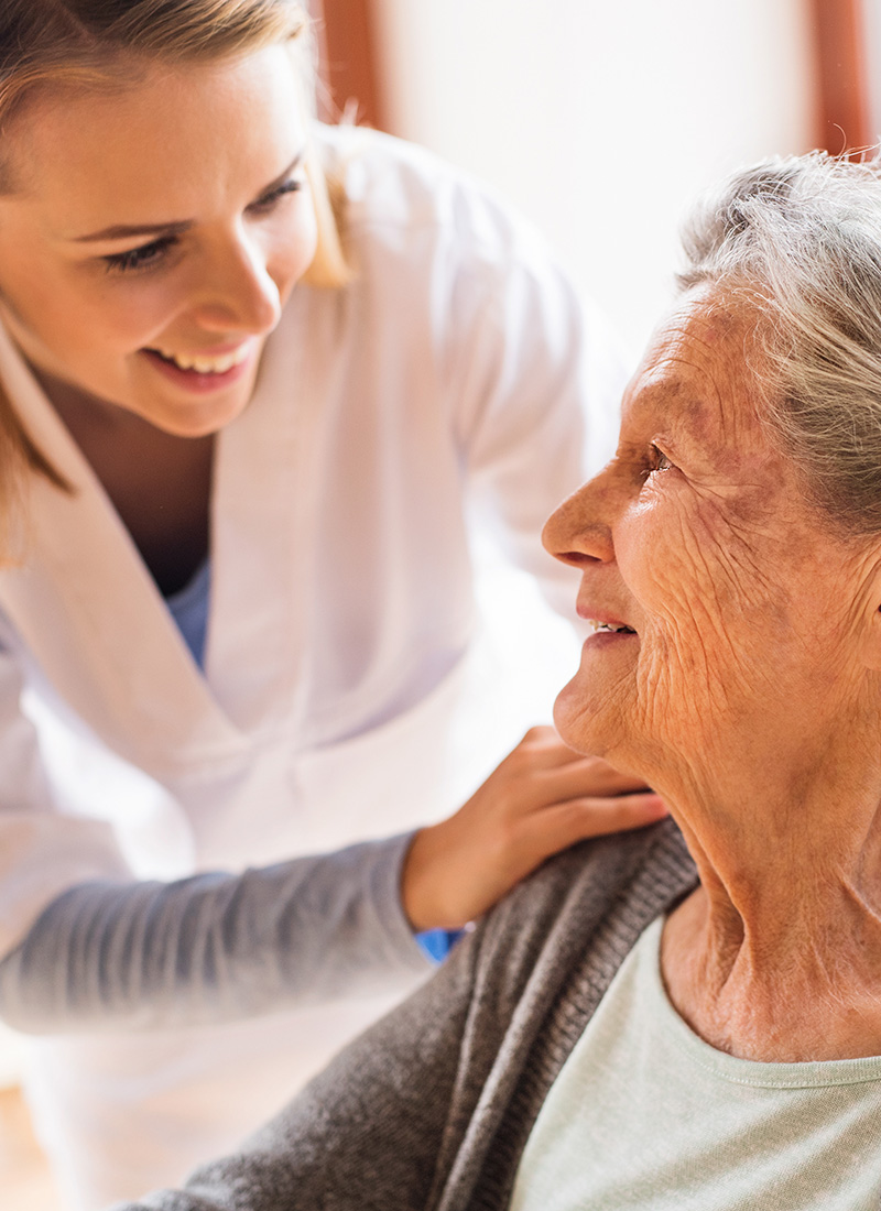 a smiling nurse with an elderly resident