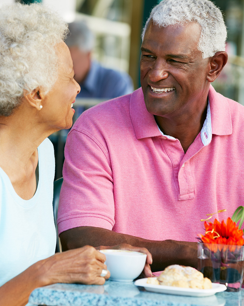 Two seniors outside dining together.